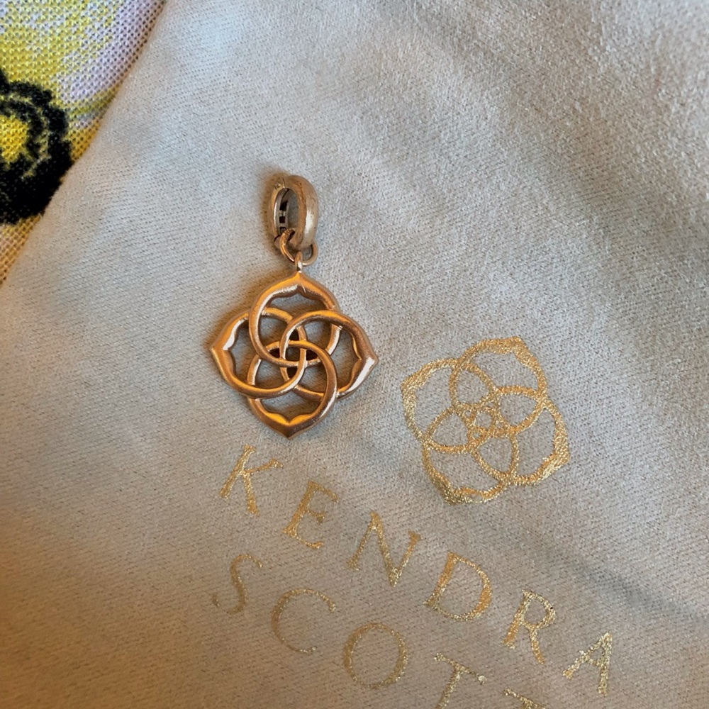 Kendra Scott rose gold logo charm.